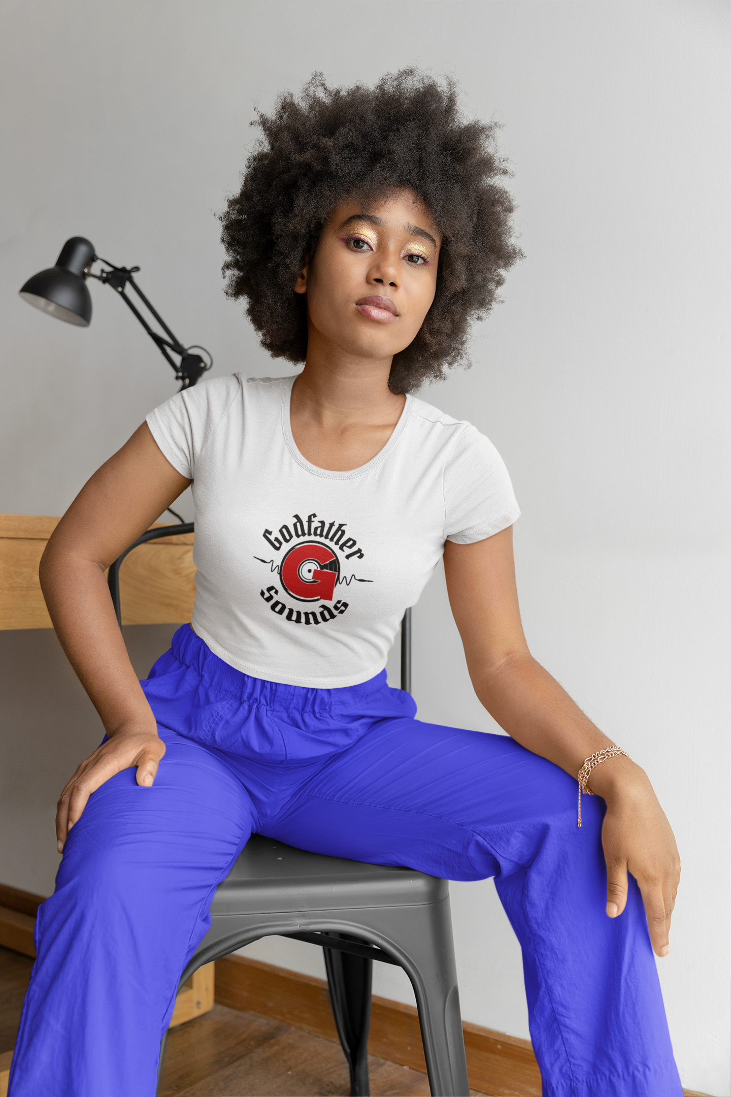 bella canvas crop top mockup of a woman with an afro hairstyle posing in a chair m29356